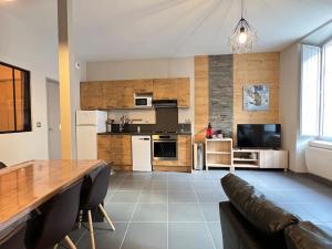 a living room with a table and a kitchen at Joli T3 rénové ds une villa 1900 in Cauterets