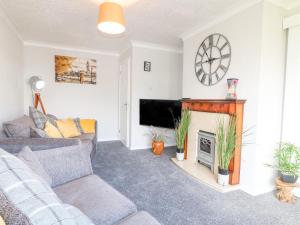 a living room with a couch and a fireplace at George's Place in Froghall