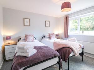 two twin beds in a bedroom with a window at George's Place in Froghall