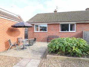 a patio with a table and chairs and an umbrella at George's Place in Froghall