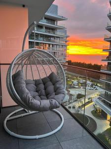 een hangstoel op een balkon met uitzicht op de stad bij Your Holidays Waves in Międzyzdroje