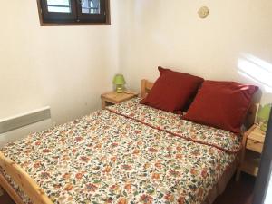 um quarto com uma cama com um edredão colorido e almofadas em Chalet du Renard em Aillon-le-Jeune