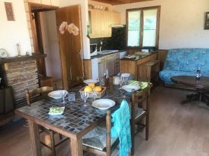 uma cozinha com uma mesa e um sofá azul em Chalet du Renard em Aillon-le-Jeune