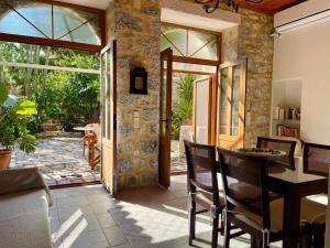 a dining room with a table and a glass door at Mani Spot -cereus in Areopoli