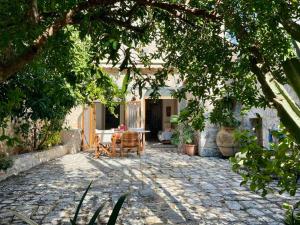 a patio with a table and chairs under a tree at Mani Spot -cereus in Areopoli