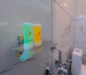 a bathroom with two bottles of soap on a glass shelf at A S Manzil Lounge in Trivandrum