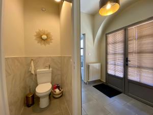 La salle de bains est pourvue de toilettes et d'une grande fenêtre. dans l'établissement Le LOUIS 16 - Maison avec jardin, à Valence
