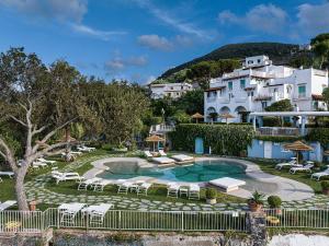 a resort with a pool and tables and chairs at Hotel Continental Mare in Ischia