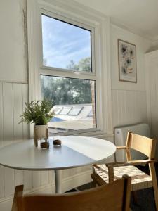 stół i krzesła w pokoju z oknem w obiekcie Gloucester Serviced Apartments w mieście Gloucester