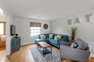 uma sala de estar com um sofá azul e uma televisão em 1 Victoria Place em Bath