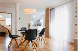a living room with a dining room table and chairs at Deluxe Maisonette Apartment Prestige 1 in Friedrichshafen