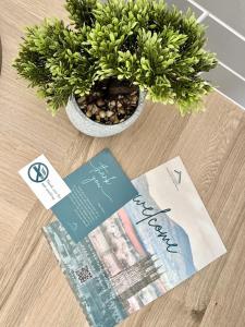 a potted plant sitting on a table next to a magazine at Gloucester Serviced Apartments in Gloucester