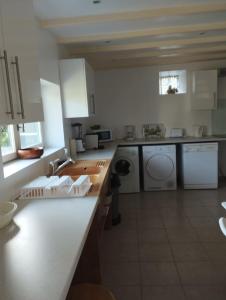 a kitchen with a sink and a washing machine at Captivating 2-Bed House with log burner in Kerien in Kérien