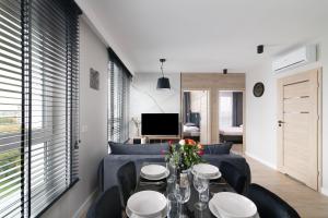 a living room with a couch and a table and chairs at EASY RENT Apartments - Kompozytorów Old Town View, Free Parking, 24h Check-in in Lublin