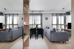 a living room with couches and a table with chairs at EASY RENT Apartments - Kompozytorów Old Town View in Lublin
