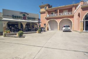 a building with a car parked in a parking lot at Omirico Studios in Corfu Town