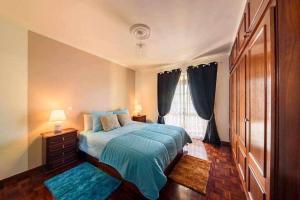 Un dormitorio con una cama azul y una ventana en Casa do Tornadouro en Ponta do Sol