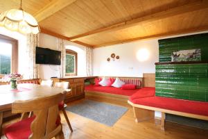 a living room with red seats and a wooden ceiling at Almliesl BREI-708 in Breitenbach am Inn