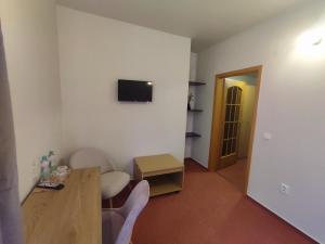Habitación con mesa y TV en la pared. en Hotel Brixen en Havlickuv Brod
