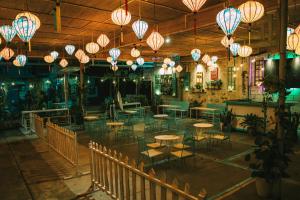 a restaurant with tables and chairs and lights at Đại Dương La Gi Homestay & Coffee in Lagi