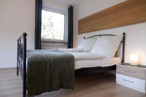 Schlafzimmer mit einem Bett und einem Fenster in der Unterkunft Gemütliches Apartment im Wald - Netflix & Prime in Marktleugast