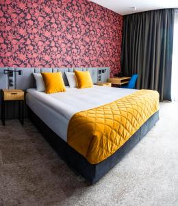 a bedroom with a large bed with a red wall at Hotel Sante in Warsaw