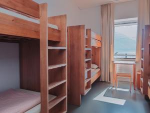 a bedroom with bunk beds with a desk and a window at Montreux Youth Hostel in Montreux