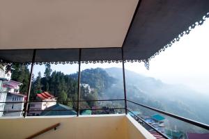 a room with a view of the mountains from a balcony at Tiara Regency Gangtok in Gangtok