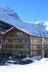 a large building with cars parked in the snow at Apartment Auenfeld in Schröcken