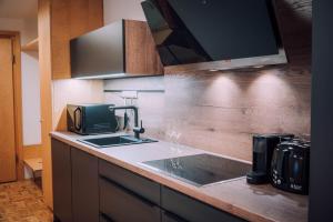 a kitchen counter with a sink and a microwave at Apartment Auenfeld in Schröcken