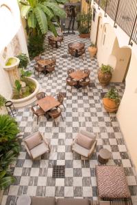 a patio with tables and chairs on a checkered floor at Relais - Palazzo Greco Stella in Lamezia Terme