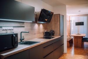 een keuken met een wastafel en een magnetron bij Apartment Auenfeld in Schröcken