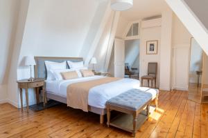 Un dormitorio con una cama grande con suelo de madera. en Château de Bonaventure, en Aulnoy