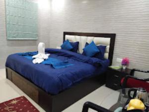 a bedroom with a blue bed with a white bird on it at Hotel Gangotri Haridwar in Haridwār
