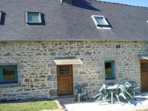 a stone building with a table and chairs in front of it at Captivating 2-Bed House with log burner in Kerien in Kérien