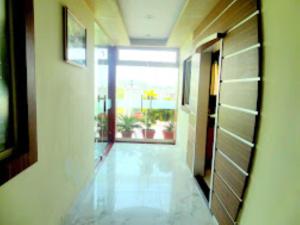 a hallway with a room with a door and a window at Hotel Gangotri Haridwar in Haridwār