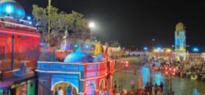 un grupo de edificios con una torre de reloj por la noche en Hotel Gangotri Haridwar, en Haridwar