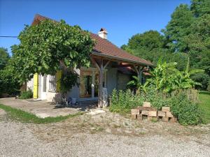 a small house with a bunch of logs in front of it at La Villa aux Bananiers 