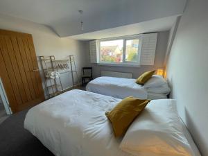 2 Betten in einem Zimmer mit Fenster in der Unterkunft Sunny Days: Beautiful Spacious 4 bed house in Torquay