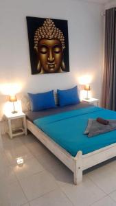 a bedroom with a large bed with a statue on the wall at Wombat's B&B in Gili Trawangan