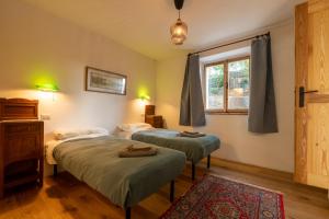 a bedroom with two beds and a window at novanta nature retreat in Bibbiena