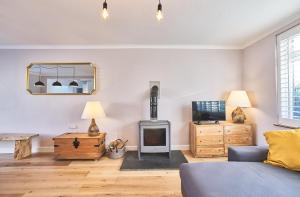 a living room with a couch and a wood stove at Sunny Days: Beautiful Spacious 4 bed house in Torquay