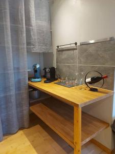 a wooden table in a room with a counter top at Logement à 6 minutes du parc des expositions. in Chavagne