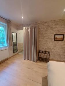 een woonkamer met een bank en een bakstenen muur bij Logement à 6 minutes du parc des expositions. in Chavagne