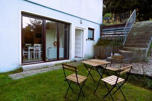 2 chaises et une table en face d'une maison dans l'établissement Gemütliches Apartment im Wald - Netflix & Prime, à Marktleugast