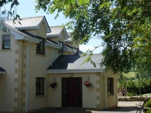 een groot wit huis met een garage bij Macreddin Rock Bed & Breakfast in Aughrim