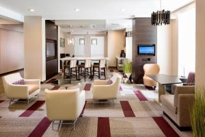 a living room with chairs and a dining room at Residence Inn by Marriott Tallahassee Universities at the Capitol in Tallahassee