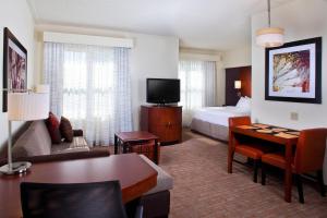 Habitación de hotel con cama y sala de estar. en Residence Inn by Marriott Tallahassee Universities at the Capitol, en Tallahassee