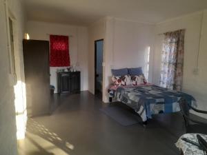 1 dormitorio con 1 cama con edredón azul en Oorslaap, en Florida