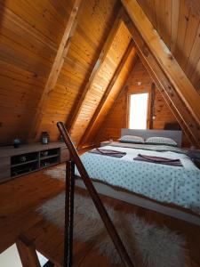 a bed in the attic of a wooden cabin at Vikendica Mimiena in Račić